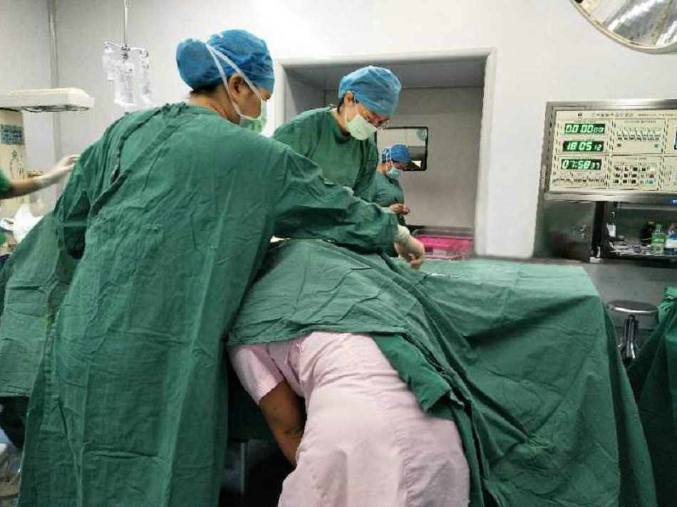 1-5、手术床无菌铺巾下，助产护士猫着身子为产妇托举胎儿的先露部。.jpg